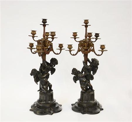 Coppia di candelabri a sette fiamme in bronzo con fusto sorretto da amorini...