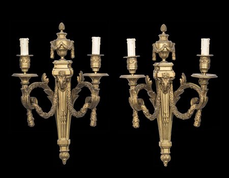 Coppia di appliques a due luci in bronzo dorato decorate in rilievo a festoni...