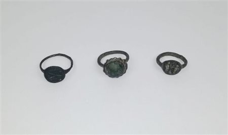 Tre anelli romani di cui due in bronzo, uno con castone e due figure umane...