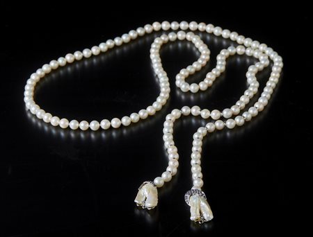  . - Collana di perle bianche coltivate in acqua saltata. 
Inserti  in oro bianco 750/1000 e terminali in madreperla con zaffiri blu di 1.20 ctt circa.
.