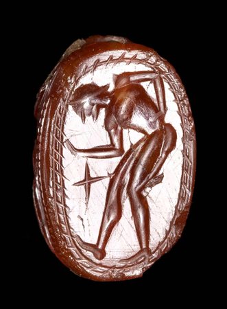 AN ETRUSCAN CARNELIAN SCARAB. MALE FIGURE WITH A STAR. 