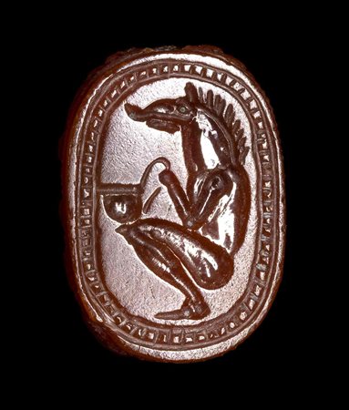 AN ETRUSCAN CARNELIAN ENGRAVED SCARAB. SEATED HYBRID FIGURE WITH A WILD BOAR'S HEAD. 