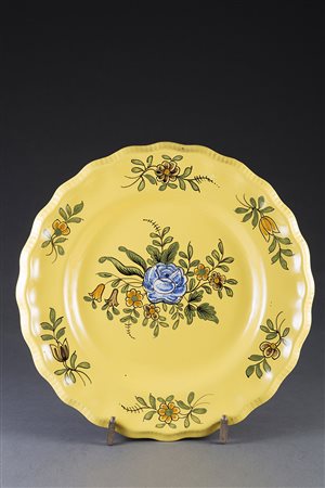 Gruppo di cinque piatti in maiolica decorata in policromia a fiori. Bordo...