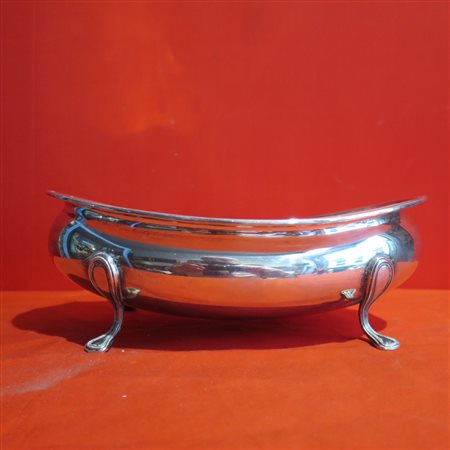 CENTRO TAVOLA IN ARGENTO, XX SECOLO A forma ovale sagomata con borduta...