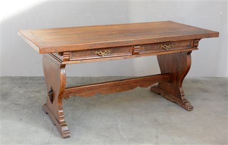 Scrivania in noce a due cassetti con montanti ad asso di coppe riuniti da...