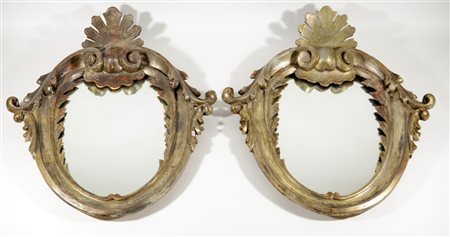 Coppia di specchiere ovali in legno intagliato a volute e argentato (cm...