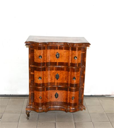 Comodino di forma sagomata lastronato in radica di noce a tre cassetti sul...