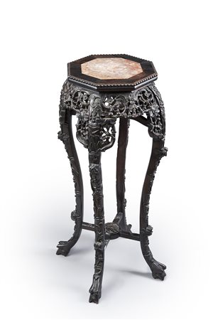 Colonna portavaso in legno ebanizzato intagliato a motivi vegetali con piano...