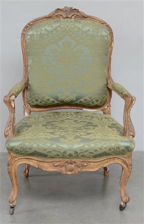 Poltrona in legno intagliato e dorato a volute e fiori. Gambe e braccioli...