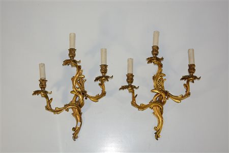Lotto di due applique in bronzo dorato a tre luci con decoro a racemi (lievi...