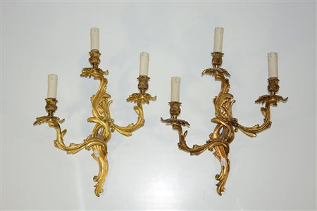 Coppia di applique in bronzo dorato a tre luci con decoro a racemi (lievi...