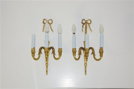 Coppia di applique a tre luci in bronzo dorato con decoro a foglie e stelo...