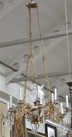 Lampadario a dodici luci in metallo dorato decorato con pendenti in cristallo...