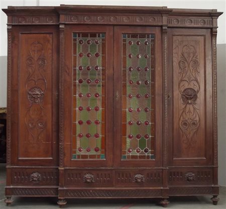 Armadio con fronte sagomato a quattro ante, intagliato a mascheroni e a...