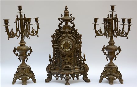 Trittico da camino in metallo dorato composto da pendola con quadrante a...