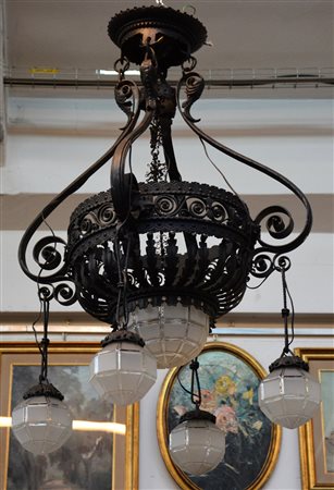 Lampadario a cinque fiamme in ferro battuto decorato a motivi vegetali con...