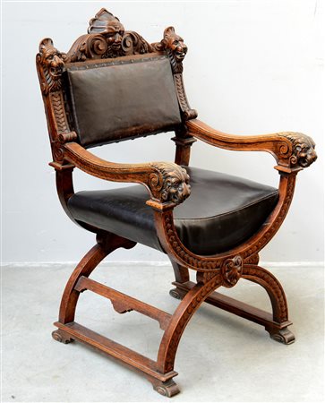 Poltrona di forma mossa in legno intagliato a volute, mascheroni e teste di...