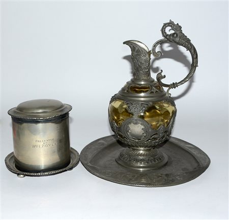 Lotto composto da una brocca, un piatto e una biscottiera in metallo...