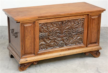 Cassapanca in noce con fronte scolpito a volute fogliate. Piedi ricciolo (cm...