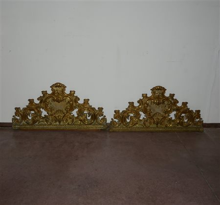 Coppia di fregi in metallo sbalzato e decorato a volute e valve di conchiglie...