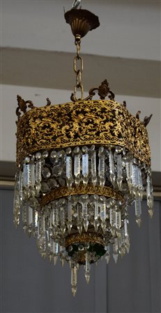 Lampadario a sei luci decorato con fregi, volute e piccole figure di putti in...