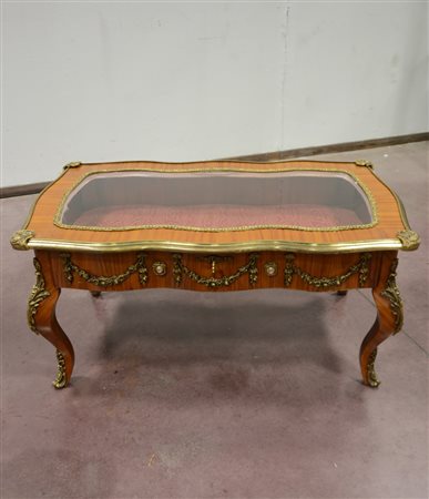 Tavolino vetrina di forma sagomata decorato con applicazioni in ottone a...