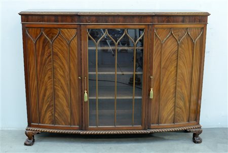 Credenzina in noce a tre ante di cui quella centrale a vetro decorate a...