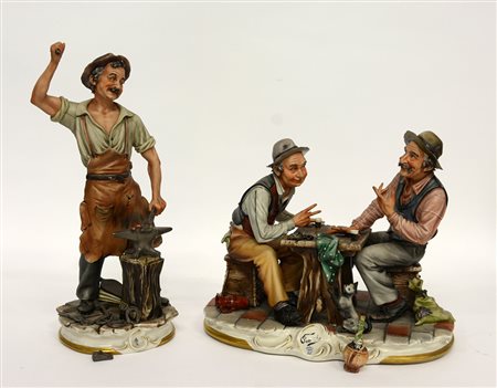 Lotto di due gruppi in porcellana policroma raffiguranti un fabbro e una...