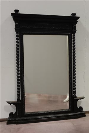 Caminiera in legno ebanizzato intagliata con mascheroni e motivi vegetali...