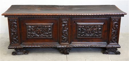 Cassapanca con fronte scolpito ad aquile bicefali e volute fogliate. Piedi a...