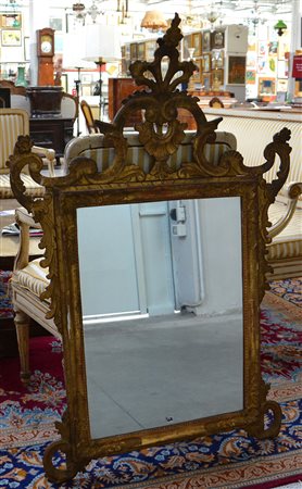 Antica specchiera in legno intagliato e dorato a volute e fiori (cm 110x74)...