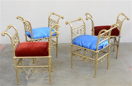 Gruppo di quattro panchetti in ottone con braccioli mossi e fregi sagomati,...