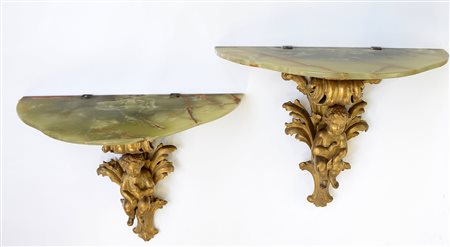 Coppia di consoline pensili in legno dorato con base intagliata con figura di...