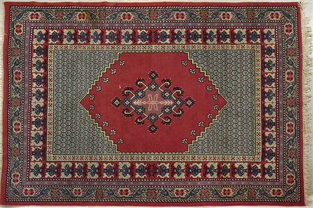 Tappeto su fondo rosso, cm. 174x220.