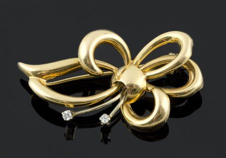 Spilla in oro giallo a forma di fiocco con due brillantini. Gr. Tot 5.