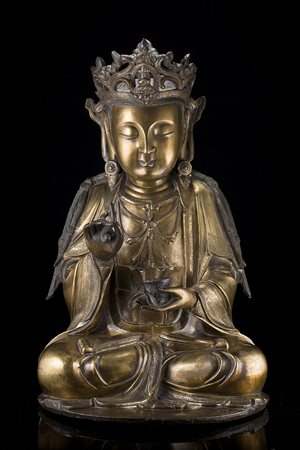 Grande Guanyin in bronzo dorato, seduta in posizione dhyanasana, nella mano...