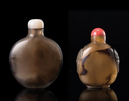 Due snuff bottles in agata, una decorata con anse a guisa di mascheroni,...