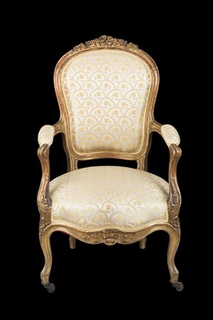Poltrona in legno intagliato e dorato con cimasa scolpita a fiori e nastri,...