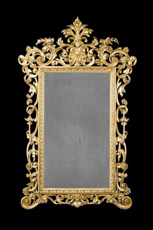 Specchiera in legno intagliato e dorato con fregi traforati e scolpiti a...