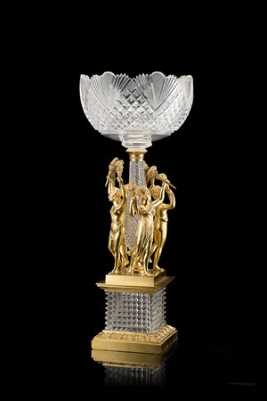 Centrotavola in cristallo con coppa molata poggiante su colonna circondata da...