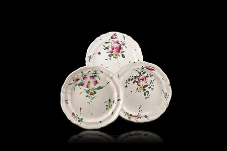 Tre piatti tondi mistilinei in maiolica con decoro policromo al terzo fuoco...