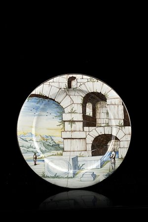 Piatto tondo foggiato a stampo in maiolica. Decorazione a gran fuoco a tutta...