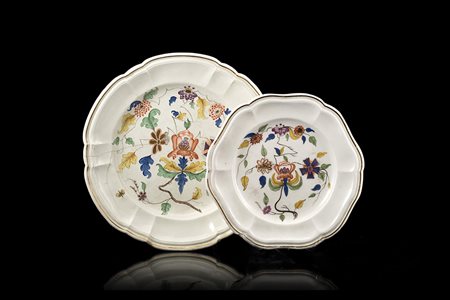 Due piatti tondi e polilobati in porcellana decorati in policromia a fiori...