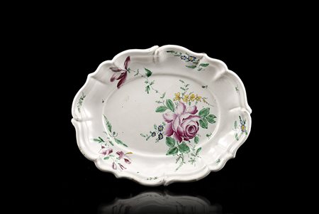 Piatto ovale costolato con bordo mistilineo. Decoro policromo ëalla rosaí....