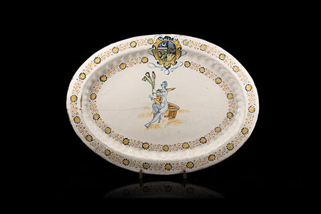 Piatto ovale con baccellature e orlo liscio in maiolica. Decorazione in stile...