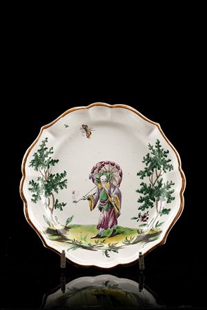 Piatto tondo mistilineo in maiolica con decoro policromo a tutta superficie...
