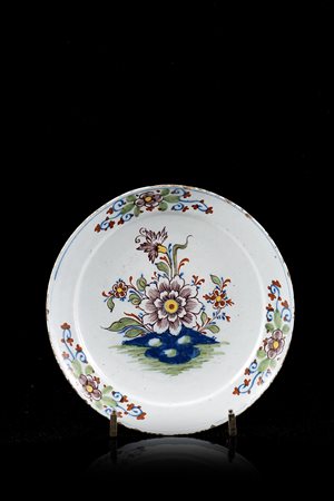 Piatto tondo a bordo liscio in maiolica. Decoro policromo a fiori...