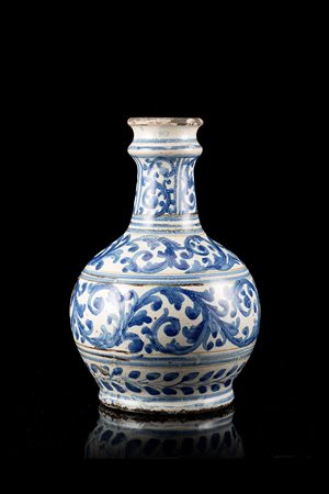 Bottiglia in maiolica con decorazione in monocromia blu a girali fogliati....