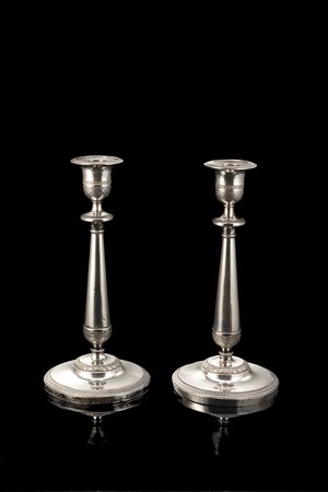 Coppia di candelieri in argento con piede circolare, fusto a balaustro e...