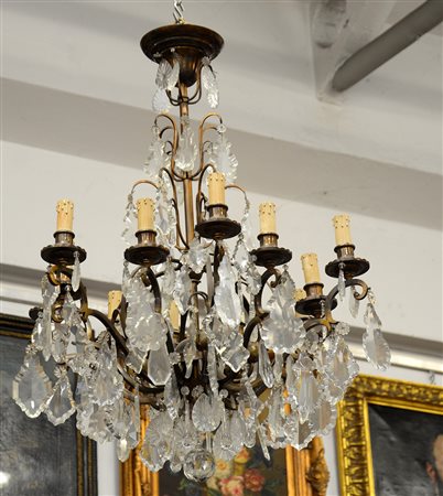Lampadario a quattordici fiamme in bronzo decorato da pendagli in cristallo...